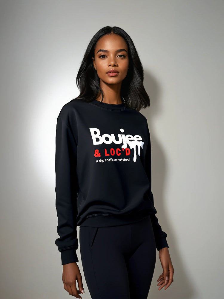Person wearing a black sweatshirt with 'Boujee & Loc'd' text on a plain background