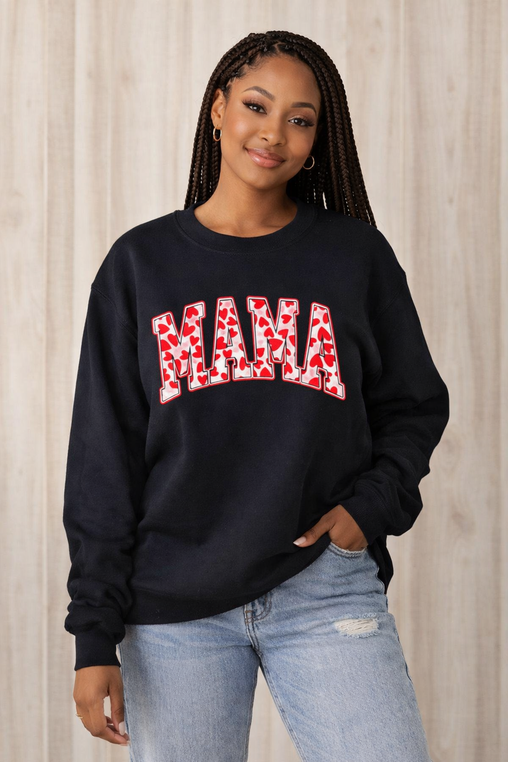Person wearing a black sweatshirt with 'MAMA' in red leopard print letters against a neutral background