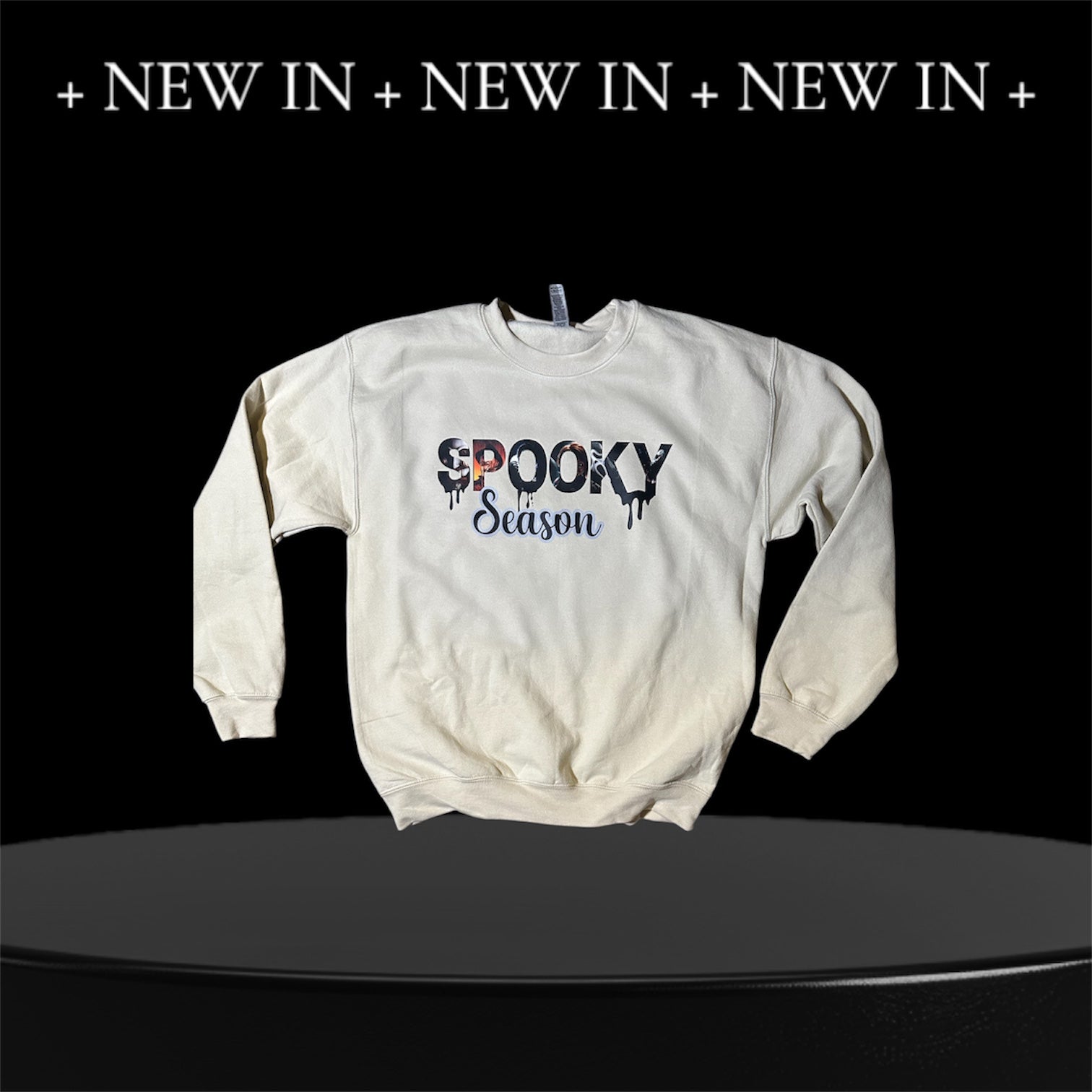 White sweatshirt with 'Spooky Season' text on a black background