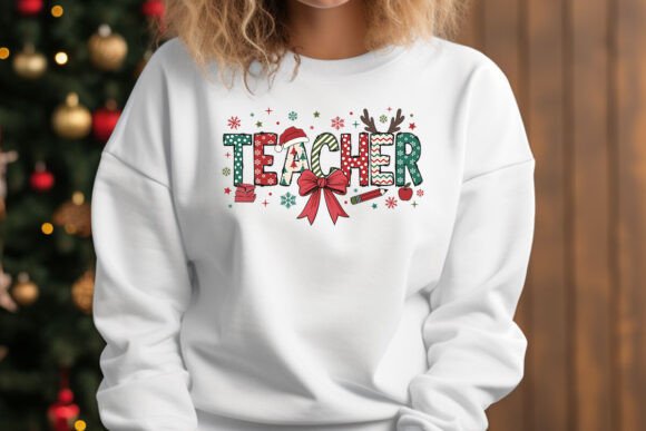 White sweatshirt with 'TEACHER' text and Christmas-themed decorations in front of a decorated Christmas tree.